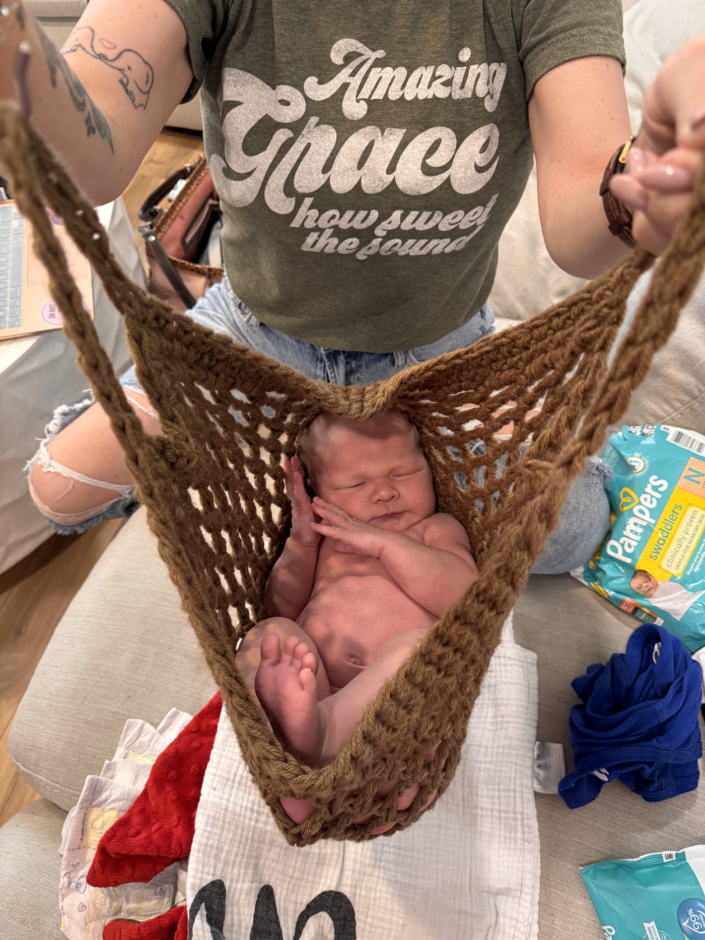 Rhonda weighing a newborn in a handmade crochet sling scale