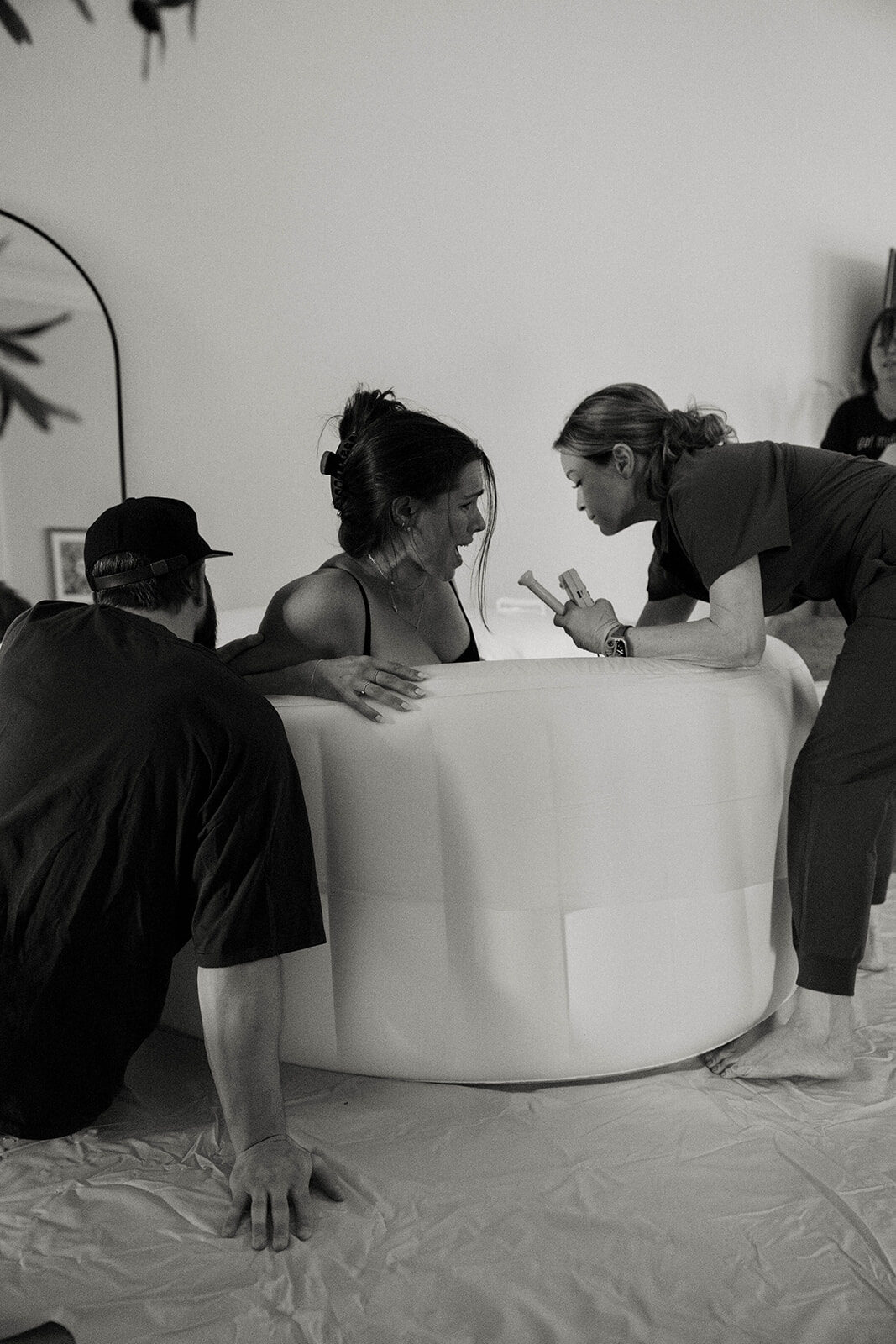 A couple embracing over the birth pool during labor
