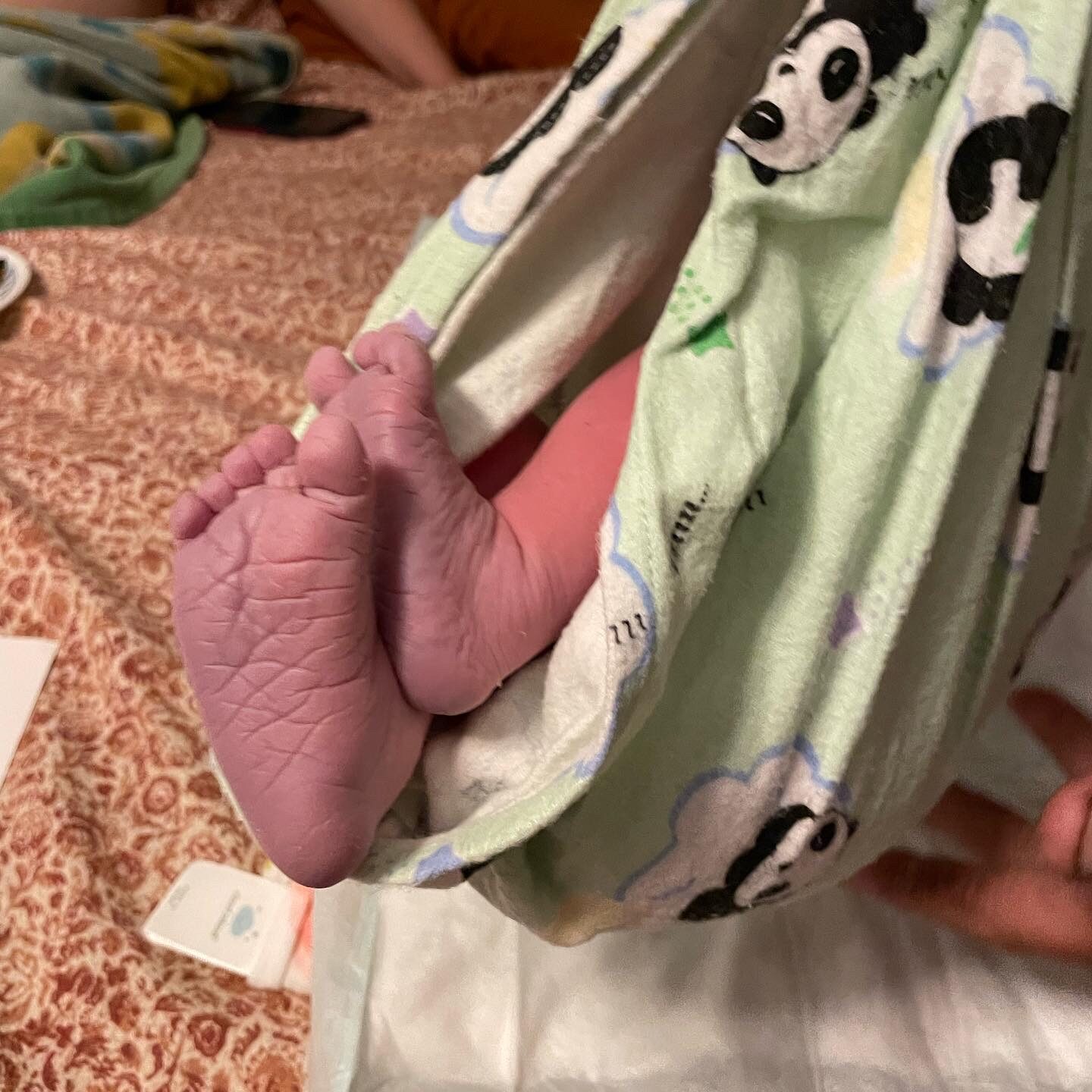 Newborn feet cradled in a soft sling