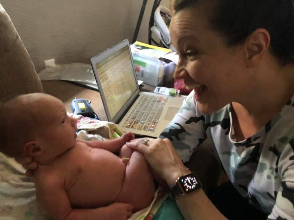 Rhonda smiling with a newborn during a visit