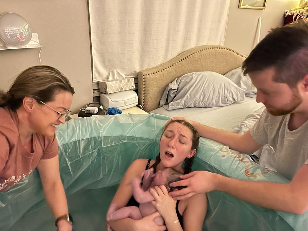 A mother meeting her just-born baby in the water during a Guardian Midwifery water birth